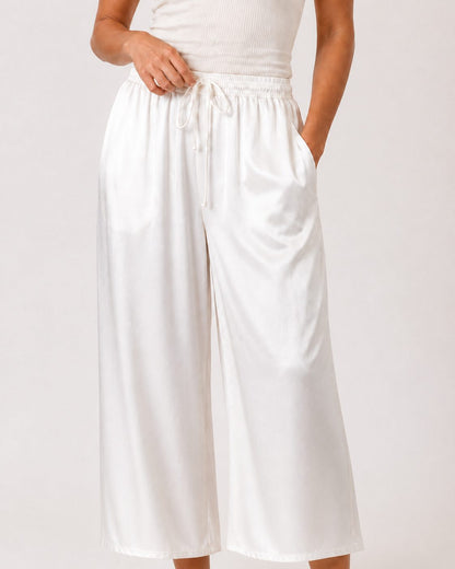 Pantaloni Amira - pantaloni palazzo ampi in raso bianco con vita arricciata e cintura da annodare