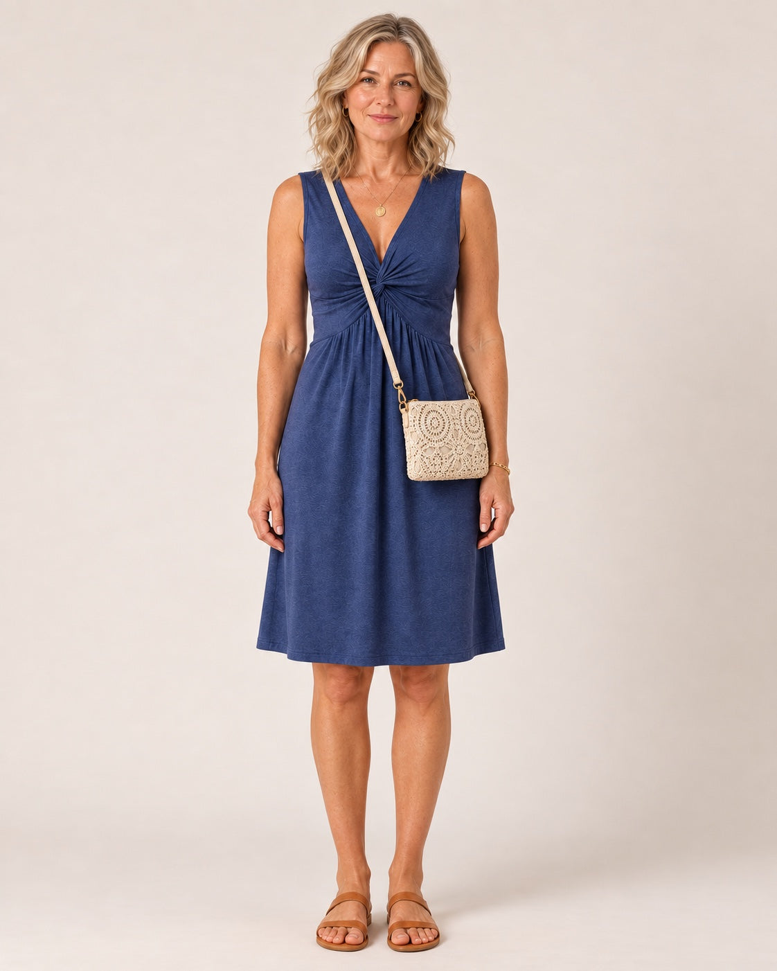 Abito Nora in jersey blu denim indossato con la borsa a tracolla color crema in crochet effetto pizzo floreale